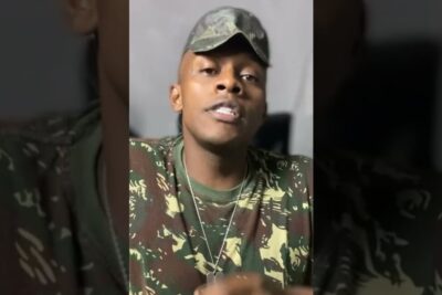 Close-up of a person wearing camouflage clothing, cap and dog tags for servico militar 2