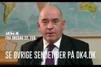 Man in suit seated before a world map with broadcast text overlay representing skabne valg.