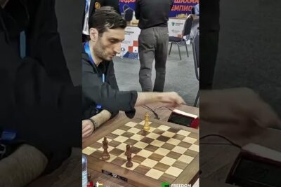 Player making a move on a wooden chessboard during a skak sport tournament.