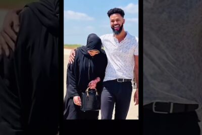 Smiling man with arm around a woman in black abaya and hijab with henna on her hands, solmia avioliitto 2