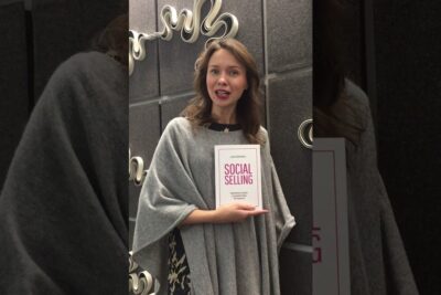 Woman holding a book titled 'Social Selling' in a studio setting illustrating sosiaalinen verkosto 4.