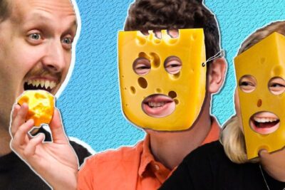Three people wearing cheese masks while one bites into a piece of cheese, spise ost