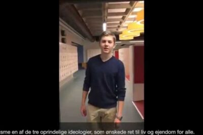 Teen standing in a school hallway by lockers, a visual reference to statens rolle.