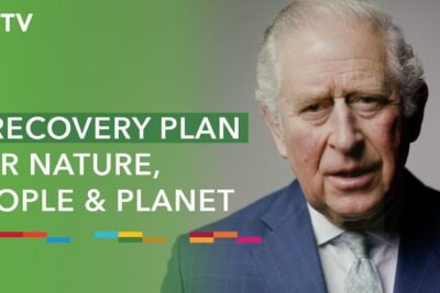 Elderly man in a suit beside a green banner promoting a sustainable future recovery plan