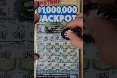 Hand scratching an instant $1,000,000 jackpot ticket to reveal numbers and a symbol pa.