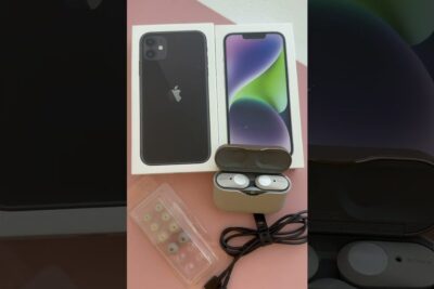 Stacked smartphone boxes next to an open wireless earbud case with extra ear tips showcasing tecnologia usada 1