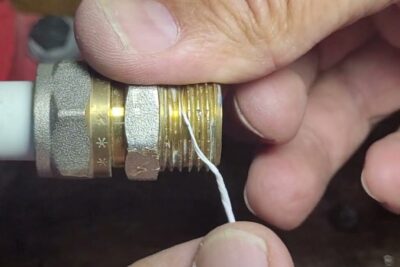 Hand wrapping teflon filettatura (PTFE tape) around a brass threaded pipe fitting to seal threads