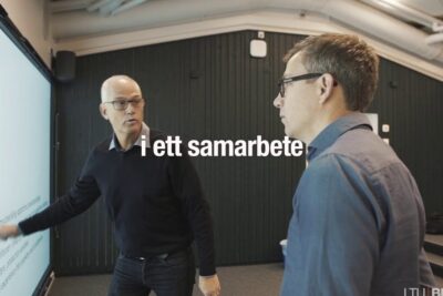 Two professionals at an interactive touchscreen discussing a technical diagram labeled tekniska innovationer 1.