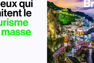 Vibrant illuminated coastal cliffside town at night with busy waterfront and signs of tourisme masse