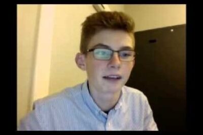 Young person wearing glasses and a striped shirt appearing engaged and ready to udtrykke meninger.