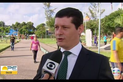 Man in a suit being interviewed with a handheld microphone in a park about uniao civil 1