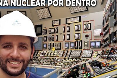 Person wearing a hard hat in a control room of usinas nucleares surrounded by monitoring panels and instruments.
