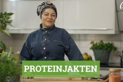 Person in a home kitchen preparing vaxtbaserad kost with fresh herbs and jars of pulses