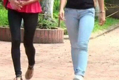 Two people walking on a paved path in casual clothing, vello pubico 1