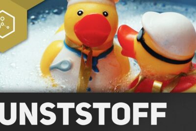 Two yellow rubber ducks in soapy bath foam illustrating verwendung kunststoffen in children's bath toys.
