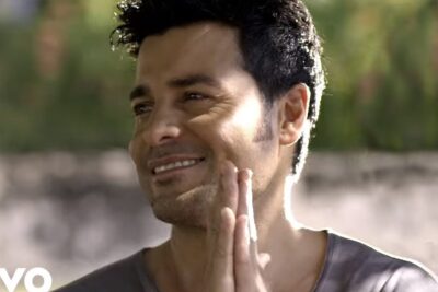 Smiling man outdoors with hands clasped and soft background, vida tierra 5