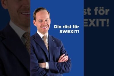 Smiling man in a navy suit with arms crossed against a blue campaign backdrop reading 'Din röst för SWEXIT!', viktig a 130.