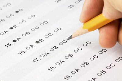 Close-up of a multiple-choice bubble answer sheet with a pencil marking choices, viktigt att double-check answers.
