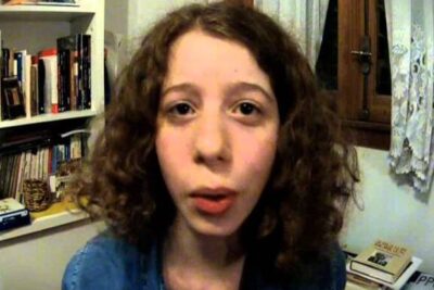 Close-up of a person with curly hair facing the camera in a home study setting for voto 16 1