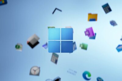 Centered blue windows 11 11 logo surrounded by floating application icons on a blurred sky-blue background