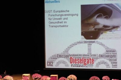 Presentation slide showing a car exhaust image and a Dieselgate word cloud linking emissions and CO2 to wissenschaftlichen forschung in transport pollution