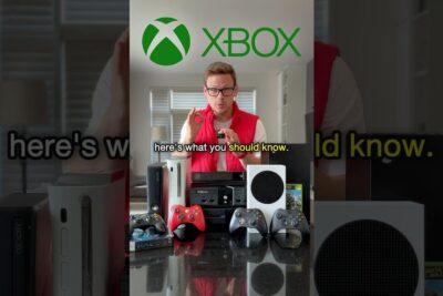 Presenter displaying a range of Xbox consoles and controllers including xbox one 6