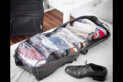 Travel shoe organizer with six clear compartments holding sneakers and a dress shoe — zapatos bolso 1.