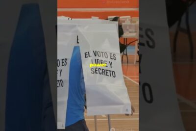 Indoor polling booths with 'El voto es libre y secreto' privacy curtains in a gym during zentralamerikanischen foderation 1.